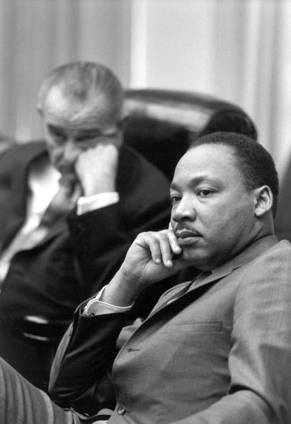 Photographic print of Dr. Martin Luther King Jr. and President Lyndon Johnson seated side by side in chairs during a Cabinet meeting, both in suits