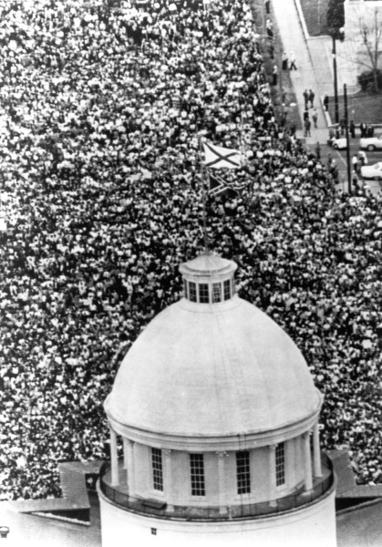 Photographic print, aerial view of a massive crowd surrounding a domed state capitol building, with a Confederate flag visible above the throng
