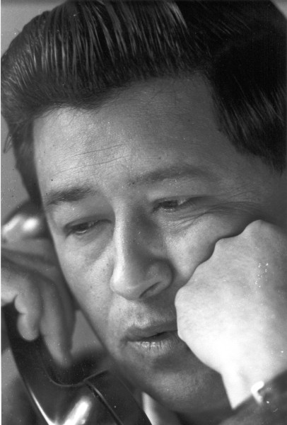 Photographic print, black-and-white close-up of Cesar Chavez holding a telephone receiver to his ear, his expression focused and intent