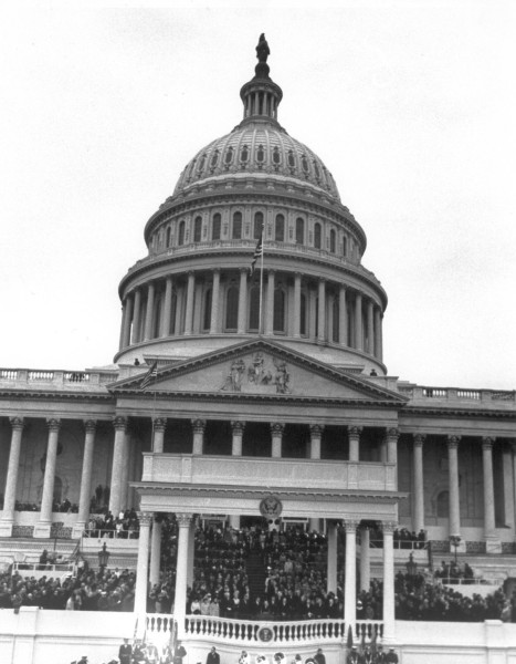 Photographic print of the U.S. Capitol dome and steps crowded with attendees on a tiered inaugural platform, 1969
