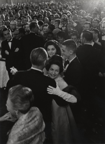 Photographic print of LBJ and Lady Bird Johnson dancing in formal attire, surrounded by a large crowd of onlookers in evening wear
