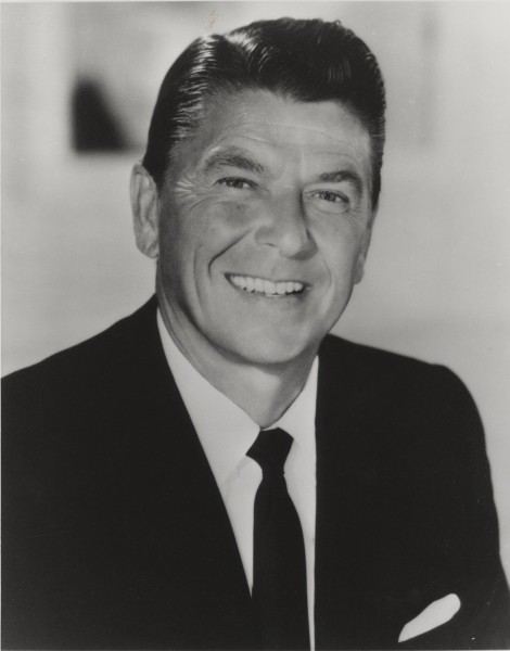 Photographic print official portrait of Ronald Reagan, smiling, wearing a dark suit, white shirt, and dark tie against a light background