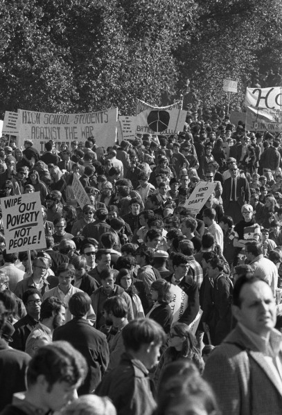 Black-and-white photograph of a dense crowd of demonstrators carrying signs reading 'Wipe Out Poverty Not People,' 'End the Draft,' and 'High School Students Against the War'